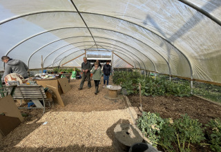 People walking inside a greenhouse at Feather Down Foxglove Farm holiday park in South East England, UK.