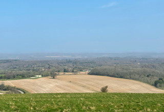 Vista de campos y bosques en el parque vacacional Feather Down Foxglove Farm en el sureste de Inglaterra, Reino Unido.