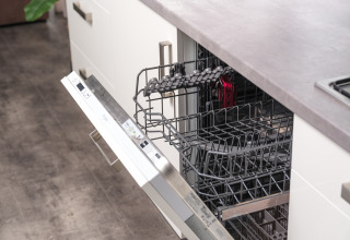 Opened dishwasher in a modern kitchen at River Cabin, Holiday Park Mölke, Netherlands, ready for dishes.