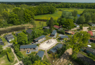 Vue aérienne du lodge 6x bungalette au Holiday Park Mölke aux Pays-Bas, entouré de verdure et d’arbres.