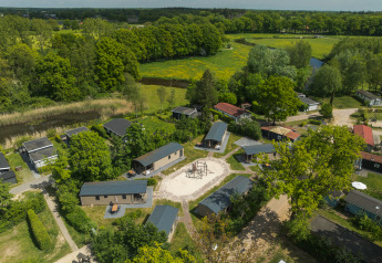 Vue aérienne du lodge 6x bungalette au Holiday Park Mölke aux Pays-Bas, entouré de verdure et d’arbres.