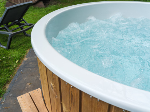 Bubbelbad buiten met houten bekleding en ligstoel bij FC Mölke stadion in Holiday Park Mölke, Nederland.