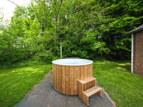 Bañera de hidromasaje de madera al aire libre junto a una cabaña en FC Mölke stadium, Holiday Park Mölke, Países Bajos.