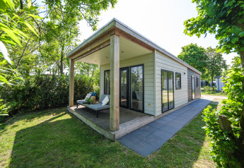 Außenansicht der River Lodge im Holiday Park Mölke in den Niederlanden, mit Terrasse und Garten.