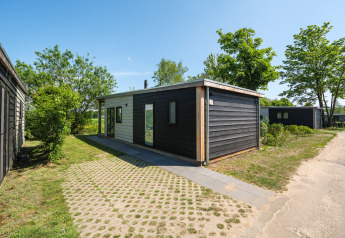 Moderne River Lodge in Holiday Park Mölke in Nederland, tussen bomen en groene omgeving.