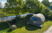 Luchtfoto van de Riverdome tiny house met badkamer en hottub bij Holiday Park Mölke, Nederland, aan het water.