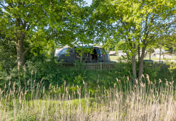 Tiny house Riverdome con bagno e vasca idromassaggio immersa nel verde a Holiday Park Mölke, Paesi Bassi.