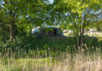 Tiny house Riverdome met badkamer en hottub, omgeven door groen bij Holiday Park Mölke, Nederland.