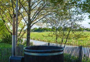 Vue sur les prairies vertes depuis un bain chaud extérieur au Riverdome, Holiday Park Mölke, Pays-Bas.