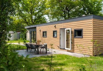 Moderne Tiny Cabin mit Holzverkleidung und Terrasse im Holiday Park Mölke, Niederlande, im Grünen gelegen.