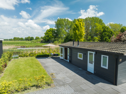 Moderne bungalow met terras en zicht op natuur bij Holiday Park Mölke in Nederland op een zonnige dag.