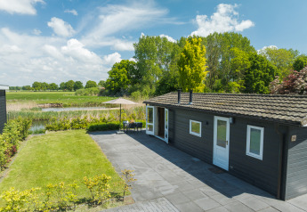 Bungalow moderno con patio e vista panoramica presso Holiday Park Mölke nei Paesi Bassi in una giornata di sole.