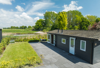 Moderne bungalow met terras en zicht op natuur bij Holiday Park Mölke in Nederland op een zonnige dag.