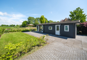 Bungalow au bord de la Regge dans le Holiday Park Mölke aux Pays-Bas, jardin, terrasse et ciel dégagé.