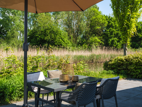 Buitenzithoek met tafel en stoelen bij bungalow aan de Regge, Holiday Park Mölke, Nederland.