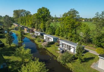 Luftaufnahme der Lodge Mistique im Ferienpark De Lochemse Berg, Niederlande, mit grüner Natur und Wasser.