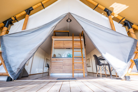 Entrada a tienda glamping de lujo frente a la playa en Zuiderzee, Países Bajos, con cocina y comedor.
