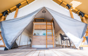 Entrada a tienda glamping de lujo frente a la playa en Zuiderzee, Países Bajos, con cocina y comedor.
