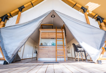 Entrée d'une tente de glamping de luxe en bord de mer à Zuiderzee, Pays-Bas, avec cuisine et coin repas.