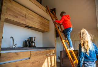 To børn leger i et luksuriøst glampingtelt ved Zuiderzee i Holland, med en hems og moderne køkken.