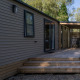 Udendørs billede af Vakantiehuis Familie (PL.82) lodge med træterrasse og overdækket siddeområde.