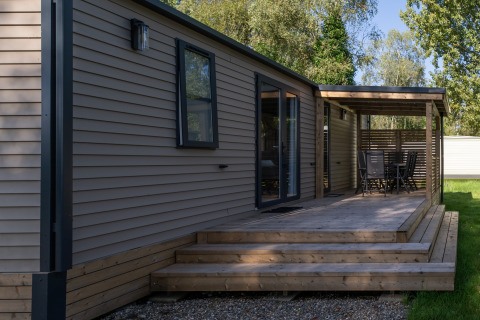 Buitenaanzicht van Vakantiehuis Familie (PL.82) lodge met houten terras en beschutte zithoek.
