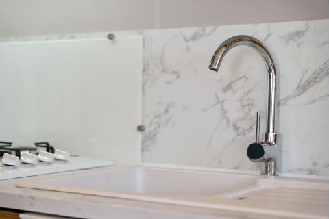 Moderne keuken met marmeren spatwand en chromen kraan in Vakantiehuis Familie op Camping Papillon.