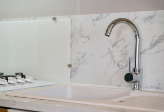 Moderne keuken met marmeren spatwand en chromen kraan in Vakantiehuis Familie op Camping Papillon.