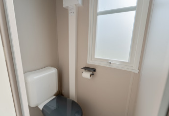 Modernes Badezimmer mit Toilette, Fenster und Toilettenpapier in Vakantiehuis Familie (PL.82) auf Camping Papillon.