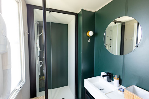 Moderne badkamer bij Vakantiehuis Familie (PL.82) op Camping Papillon in België, met douche en rond spiegel.