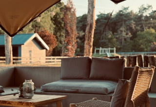 Outdoor seating area with wooden furniture at Thuysgrond holiday park, North-Brabant, Netherlands, scenic view.