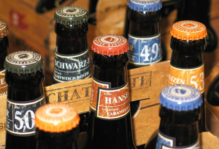 Forskellige ølflasker med farverige kapsler i en trækasse, fotograferet nær Bergeijk, Noord-Brabant, Holland.