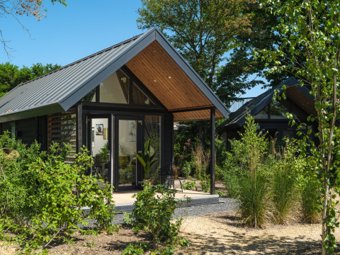 Sommer-Lodge im Erholungspark und Yachthafen Rhederlaagse Meren in den Niederlanden, umgeben von Grün.