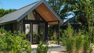 Summer Lodge en el parque recreativo y puerto deportivo Rhederlaagse Meren en los Países Bajos, rodeado de vegetación.
