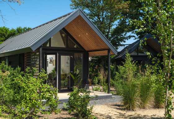 Summer Lodge en el parque recreativo y puerto deportivo Rhederlaagse Meren en los Países Bajos, rodeado de vegetación.