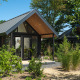 Sommer-Lodge im Erholungspark und Yachthafen Rhederlaagse Meren in den Niederlanden, umgeben von Grün.