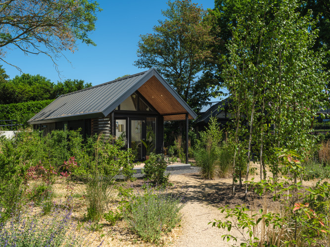 Cabaña Summer Lodge en el Recreation park y Marina Rhederlaagse Meren en los Países Bajos, rodeada de vegetación.
