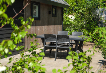 Outdoor dining area at Summer Lodge, Recreation park and Marina Rhederlaagse Meren, Netherlands, with garden view.