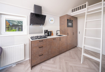 Moderne Küchenzeile mit Hochbett-Leiter im Summer Lodge im Park Rhederlaagse Meren, Niederlande.
