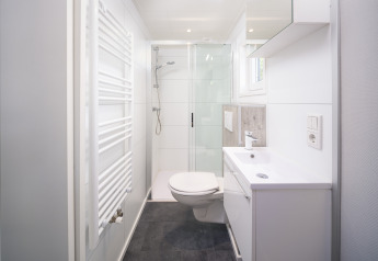 Modern, bright bathroom at Summer Lodge in Rhederlaagse Meren, with shower, sink, and toilet.