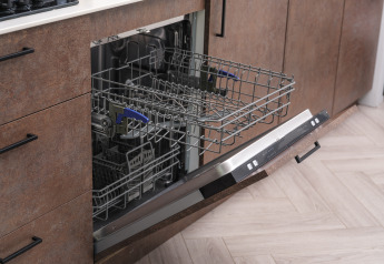 Open dishwasher with pulled-out rack in the kitchen at Summer Lodge, Rhederlaagse Meren, Netherlands.