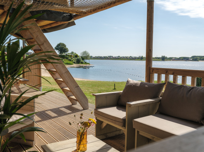 View from the safari tent terrace at Recreation park and Marina Rhederlaagse Meren with sofa and lake.
