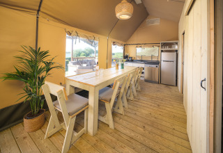 Interior de la tienda Safari Ranger con mesa de comedor y cocina en Rhederlaagse Meren, Países Bajos.