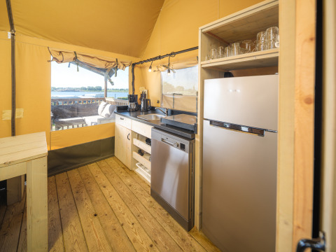 Cocina interior de la tienda Safari tent Ranger en Rhederlaagse Meren, con vista al lago y la naturaleza.