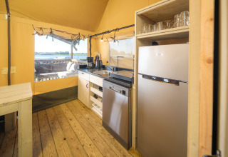 Interior kitchen area of Safari tent Ranger at Rhederlaagse Meren, overlooking lake and nature.