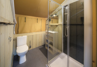 Baño moderno en tienda safari con ducha, inodoro y lavabo en el parque Rhederlaagse Meren, Países Bajos.
