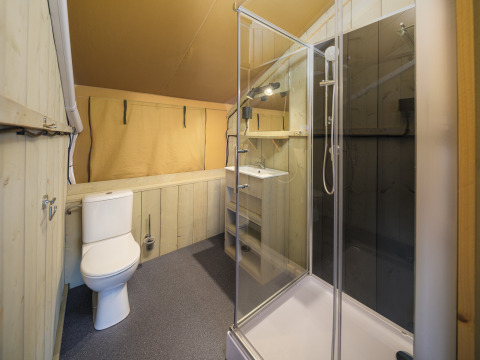 Moderne badeværelse i safaritelt med bruser, toilet og vask på Recreatiepark Rhederlaagse Meren i Holland.