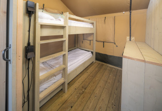 Binnenzicht van Safari tent Ranger bij Rhederlaagse Meren, ingericht met stapelbedden en houten vloer.