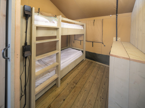 Interieur van Safari tent Ranger bij Rhederlaagse Meren met stapelbedden en houten vloer in Nederland.