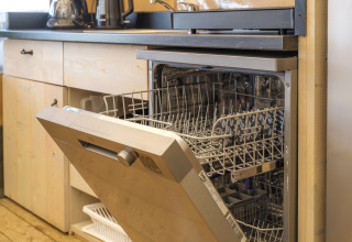 Open dishwasher in the kitchen of a safari tent at Rhederlaagse Meren recreation park in the Netherlands.